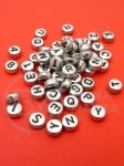 Mărgele 7x4mm litere metalizate MIX gaură 1mm 1 pachet 100 buc 1000-14.00 318599